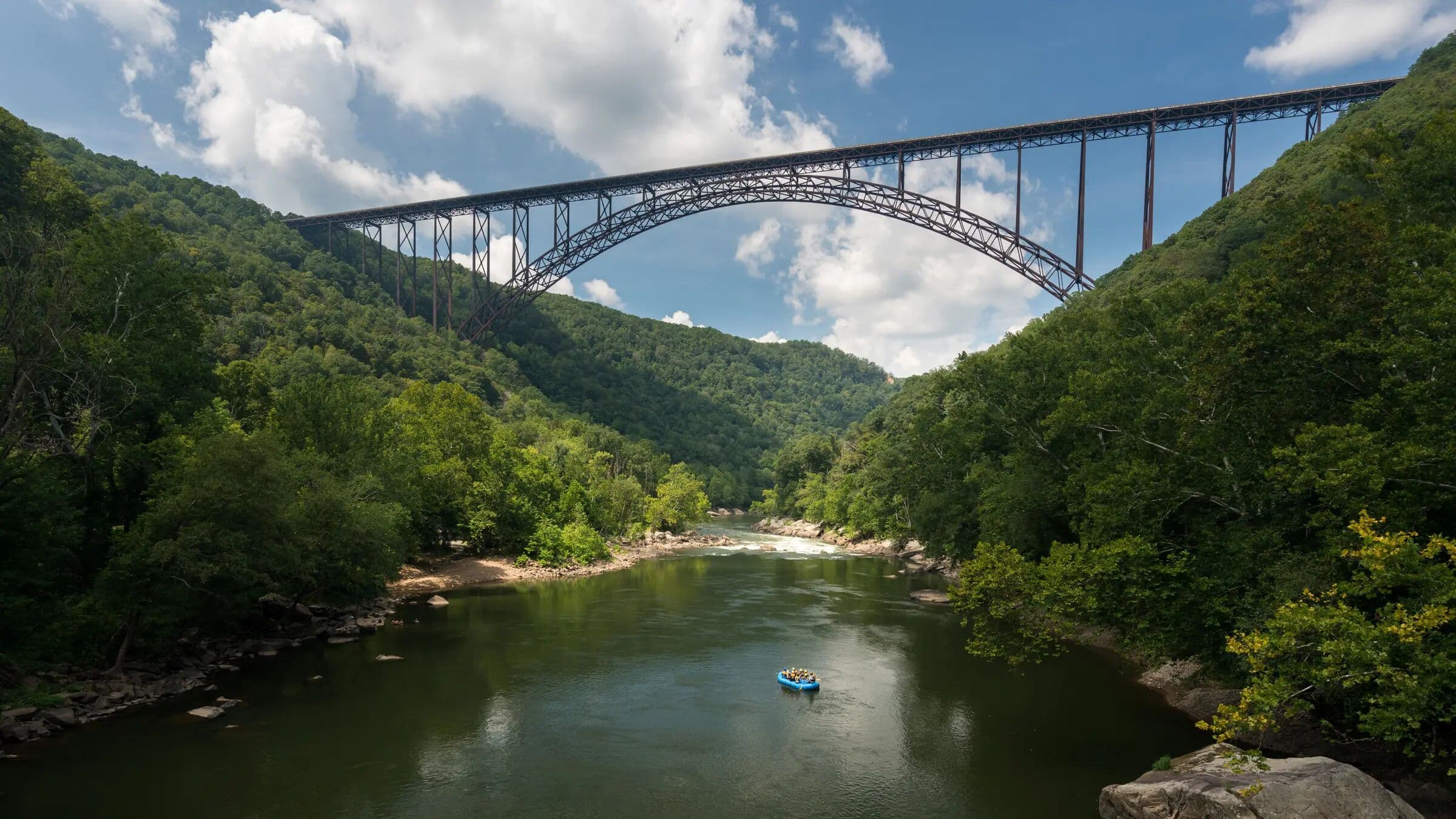 New River Gorge Bridge spanning the canyon with rafters below